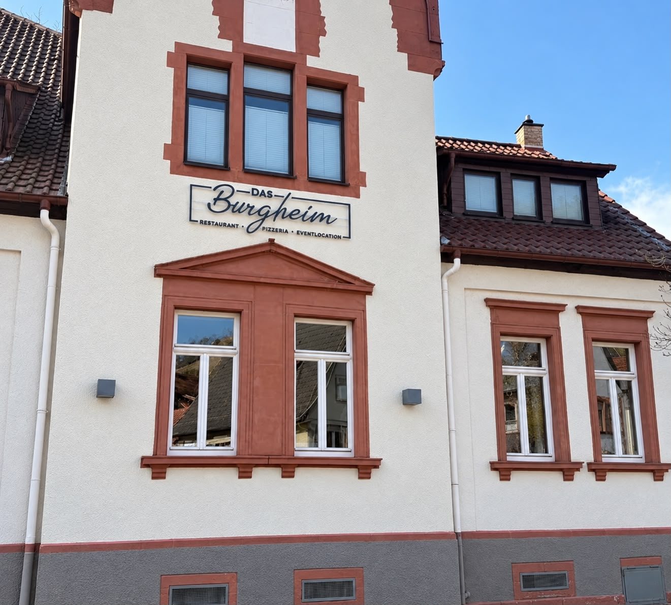 Außenansicht des Burgheims am Graben mit Schild „Das Burgheim“