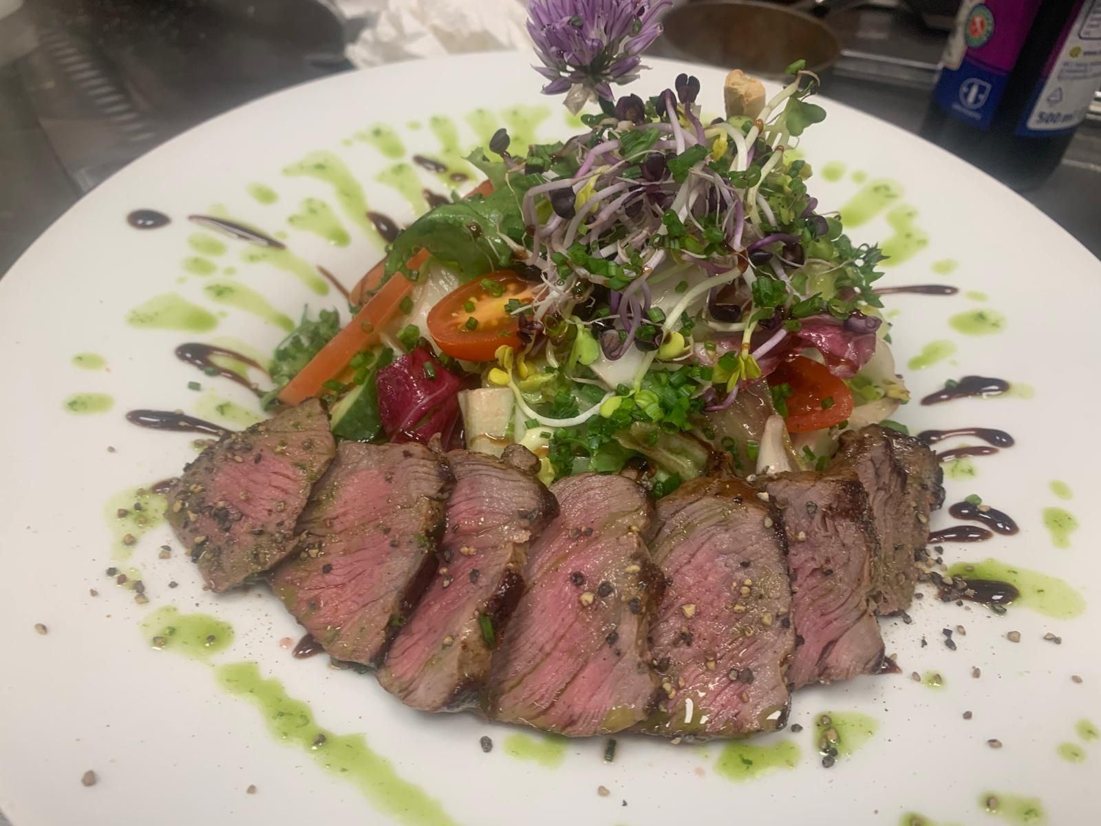 Rosa gebratenes Fleisch mit Salat