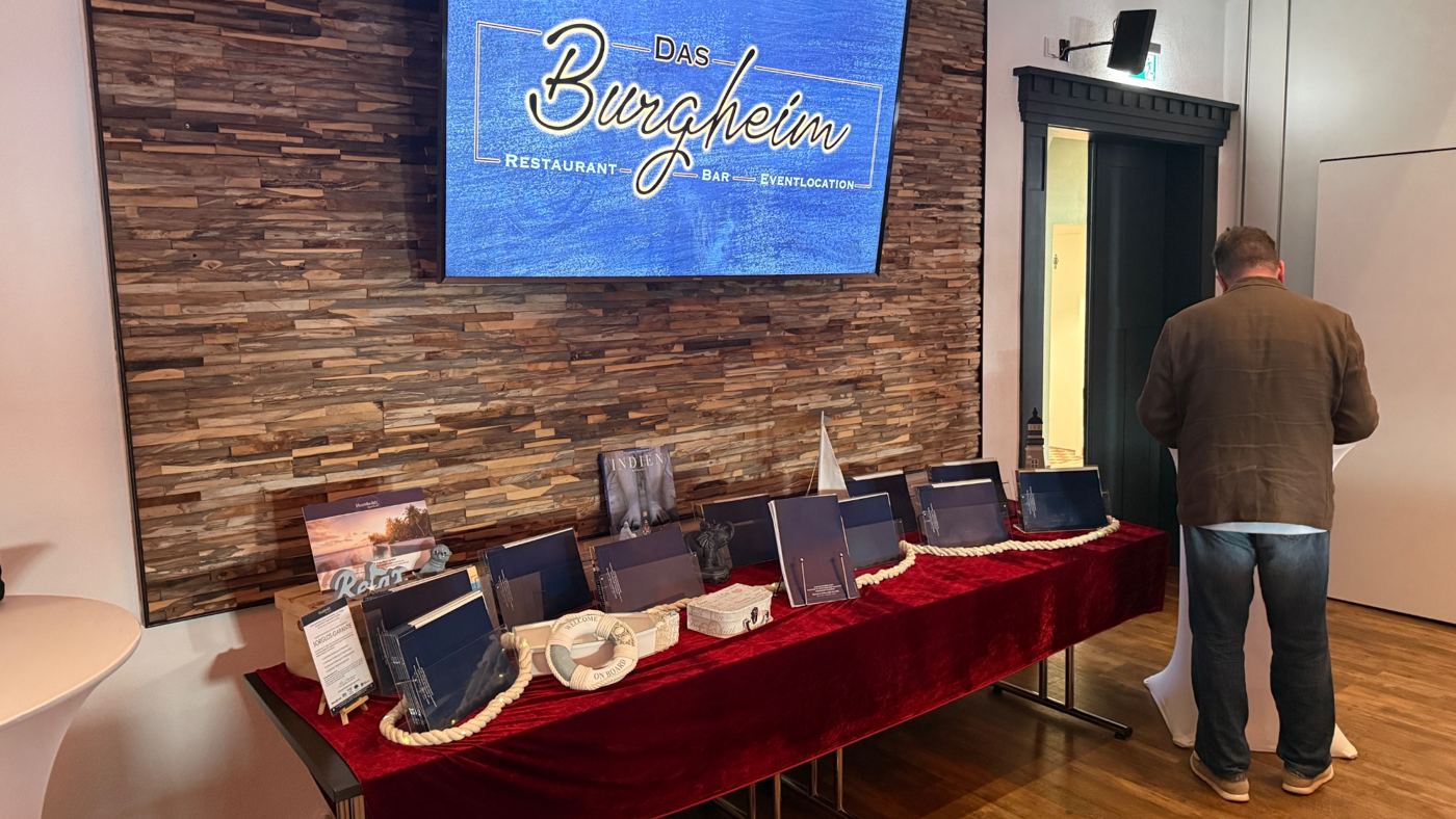Ausstellung im Saal mit Burgheim-Logo auf dem Bildschirm
